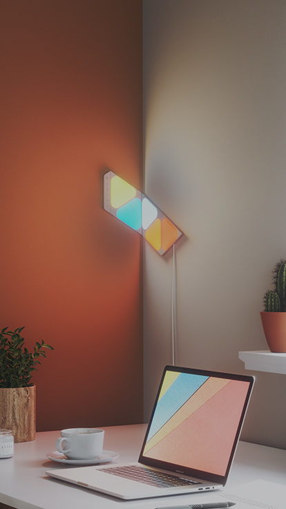 此圖片顯示在書桌上 Nanoleaf Shapes 迷你三角形智能燈板的 5 個面板佈局。 此設計利用可扭曲連接片，貼合書桌的角落。 智能燈是您在工作時尋找靈感及提高生產力的最佳選擇。