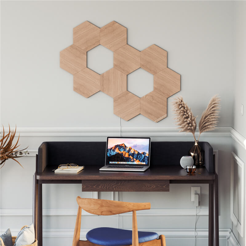 Ô đèn thông minh dạng mô-đun hình lục giác vân gỗ Nanoleaf Elements Thread-enabled được gắn lên tường trong phòng làm việc ở nhà. HomeKit, Google Assistant, Amazon Alexa, IFTTT.