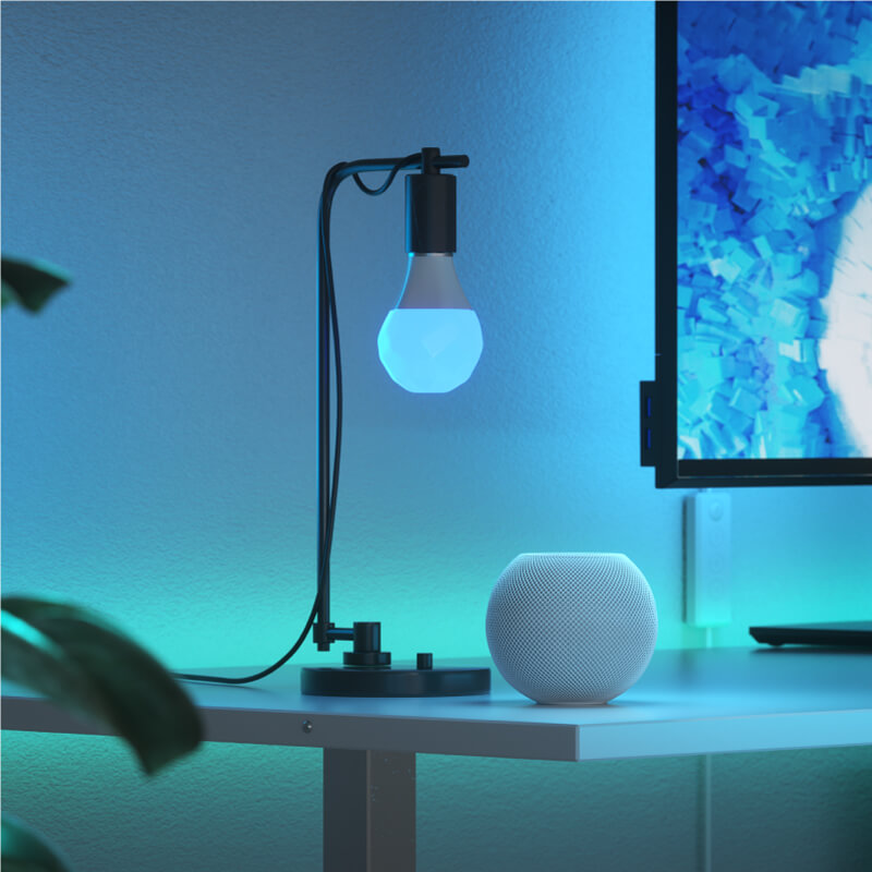Bóng đèn thông minh thay đổi màu sắc Nanoleaf Essentials Thread-enabled được gắn vào một vật cố định trong phòng làm việc ở nhà. Tương tự với Wyze. HomeKit, Google Assistant, Amazon Alexa, IFTTT. 