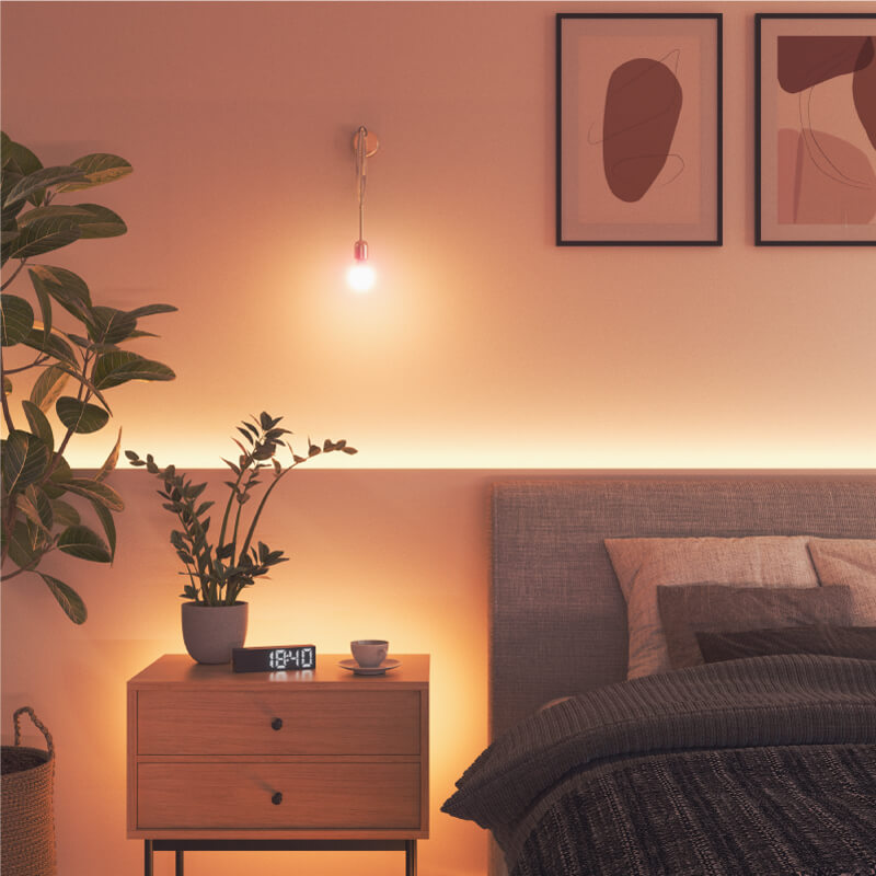 Nanoleaf Essentials Thread enabled color changing smart light bulb mounted to a fixture in a bedroom. Similar to Wyze. HomeKit, Google Assistant, Amazon Alexa, IFTTT.
