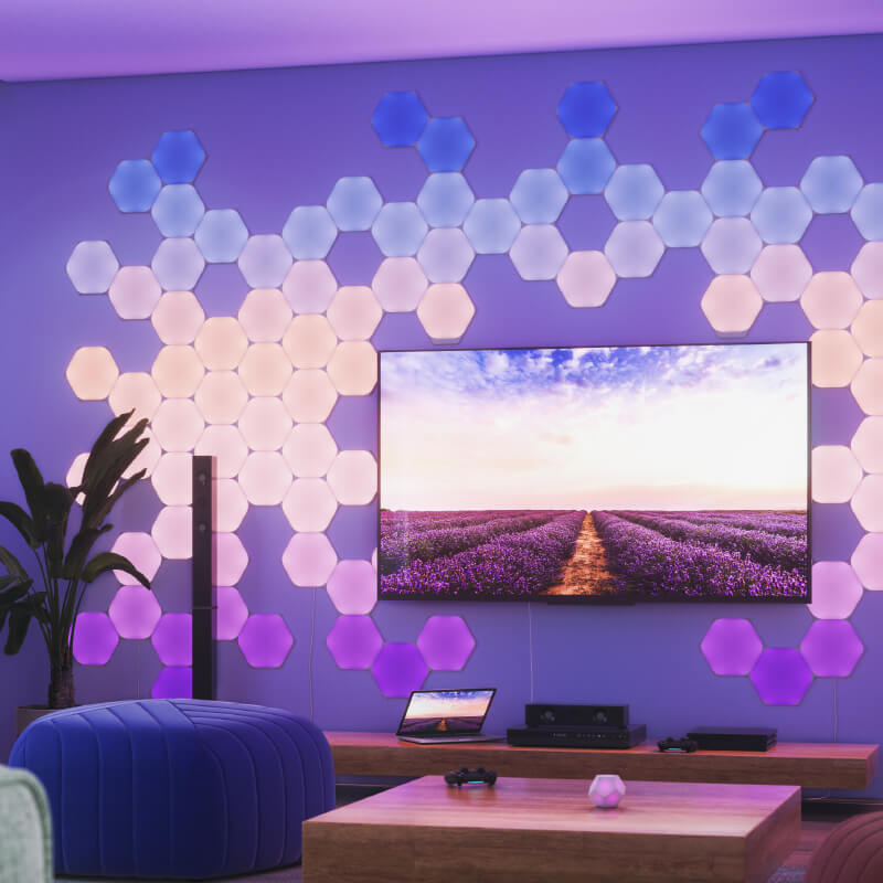 Light panels modular pintar heksagon yang dapat berubah warna dengan Thread Nanoleaf Shapes yang dipasang pada dinding di ruang tamu. Mirip dengan Philips Hue, Lifx. HomeKit, Google Assistant, Amazon Alexa, IFTTT.