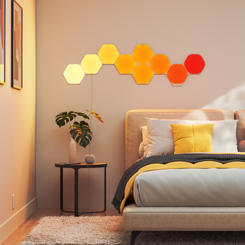 Light panels modular pintar heksagon yang dapat berubah warna dengan Thread Nanoleaf Shapes yang dipasang pada dinding di kamar tidur. Mirip dengan Philips Hue, Lifx. HomeKit, Google Assistant, Amazon Alexa, IFTTT. 