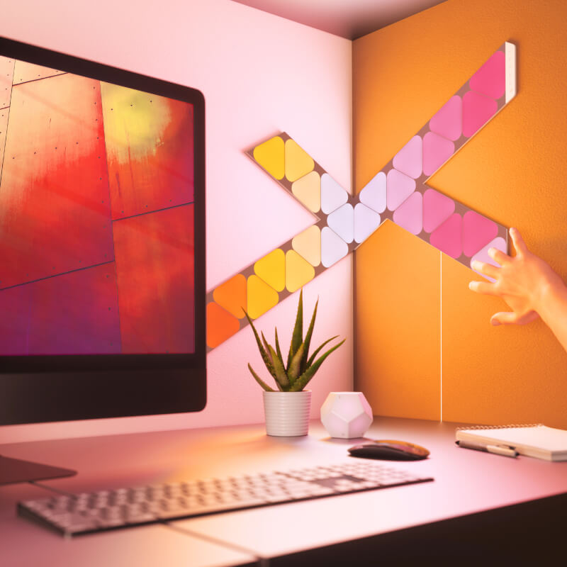 Light panels modular pintar triangle mini yang dapat berubah warna dengan Thread Nanoleaf Shapes yang dipasang pada dinding di atas meja. Mirip dengan Philips Hue, Lifx. HomeKit, Google Assistant, Amazon Alexa, IFTTT. 