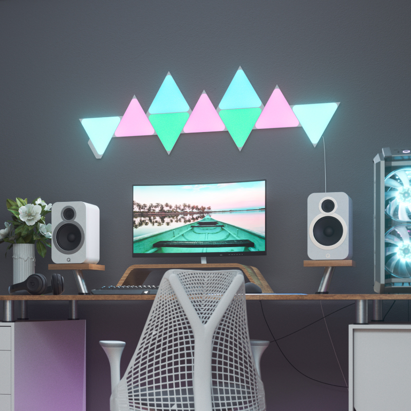Nanoleaf Shapes Thread-enabled color-changing triangle smart modular light panels mounted to a wall above a battlestation. Similar to Philips Hue, Lifx. HomeKit, Google Assistant, Amazon Alexa, IFTTT. 